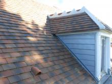 Rénovation de couverture en tuiles (Vieux Clocher) avec écran pare-pluie sous les lattes (meilleure isolation). Arêtiers en ciment comme recommandé par les Bâtiments de France et jouées de lucarne en zinc mat. (Après)