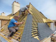 Rénovation d'une couverture Shingle en ardoises posées aux crochets. Les cheminées sont enduites et les lucarnes sont refaite en béton et habillées en zinc prépatiné noir (Pendant)