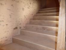 Réalisation d'un escalier en béton, avec marches balancées. Habillage des marches en pierres et murs enduits à pierres vues. (Après)