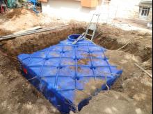 Installation d'une cuve de récupération des eaux de pluie de 3000L équipée d'une pompe pour l'arrosage des végétaux.