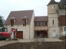 Démolition du garage existant (à gauche) et construction du nouveau garage relié à l'habitation par une galerie en charpente bois. 
Agrandissement de la partie haute de la tour avec les moellons de l'ancien garage, enduit à pierres vues et entablement en pierre. (Après)