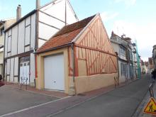 Restauration des pans de bois masqué par un enduit. Peinture  légèrement orangée et remplissage en enduit à la chaux couleur ocre. (Après)