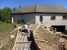 Coulage en béton de l'allée ,des rangs de briques permettent le fractionnement de la dalle et agrémente le béton taloché.