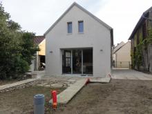 Percement d'une baie de 3,50m et 2 fenêtres à l'étage. Enduit à la chaux aérienne finition talochée. Terrasse et allée. (Après)