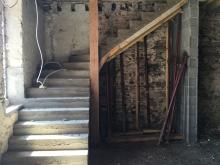Réalisation d'un escalier en béton, avec marches balancées. Habillage des marches en pierres et murs enduits à pierres vues. (Avant)