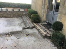 Réfection de terrasse en pavés Porphyre posés sur chape et couronnement des murets en pierre. (Pendant)