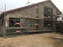 Construction d'un atelier avec briques en plaquettes, chaine d'angle, linteaux et jambages en terre cuite, enduit aspect gratté et bloc de pierre incrusté pour décoration. (Pendant)