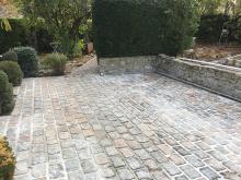 Réfection de terrasse en pavés Porphyre posés sur chape et couronnement des murets en pierre. (Après)