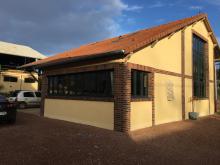 Construction d'un atelier avec briques en plaquettes, chaine d'angle, linteaux et jambages en terre cuite, enduit aspect gratté et bloc de pierre incrusté pour décoration. (Après)