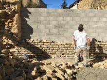 le mur de clôture est refait en pierres issues de la démolition.