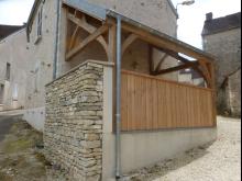 Modification d'un auvent en tôle ondulée, en charpente chêne avec mur en pierres de récupération et enduit à la chaux. (Après)