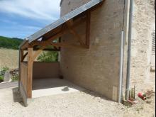 Modification d'un auvent en tôle ondulée, en charpente chêne avec mur en pierres de récupération et enduit à la chaux. (Après)