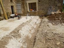 Aménagement d'une terrasse d'une ancienne écurie. Remblai au niveau des seuils, fondations, murets en parpaings et moellons issus de l'écurie, carrelage en pierre multiformat, spots encastrés dans la dalle et escalier en pierre et béton. (Pendant)